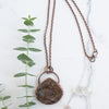 Labradorite and Copper necklace beside a green eucalyptus branch.