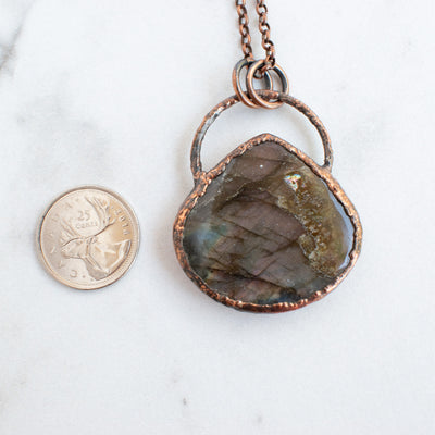 Labradorite pendant shown beside a Canadian quarter coin.