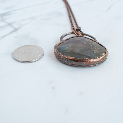 Labradorite pendant shown beside a Canadian quarter coin.