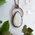 Large Rainbow Moonstone and Copper healing necklace shown beside quartz crystals and greenery.