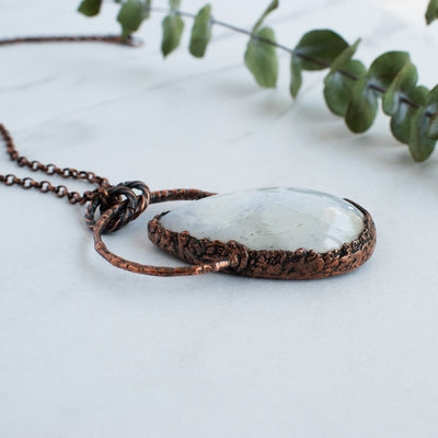 The side view shows the texturization of this Rainbow Moonstone and copper necklace.