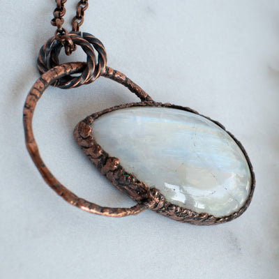 The side view shows the texturization of this Rainbow Moonstone and copper necklace.