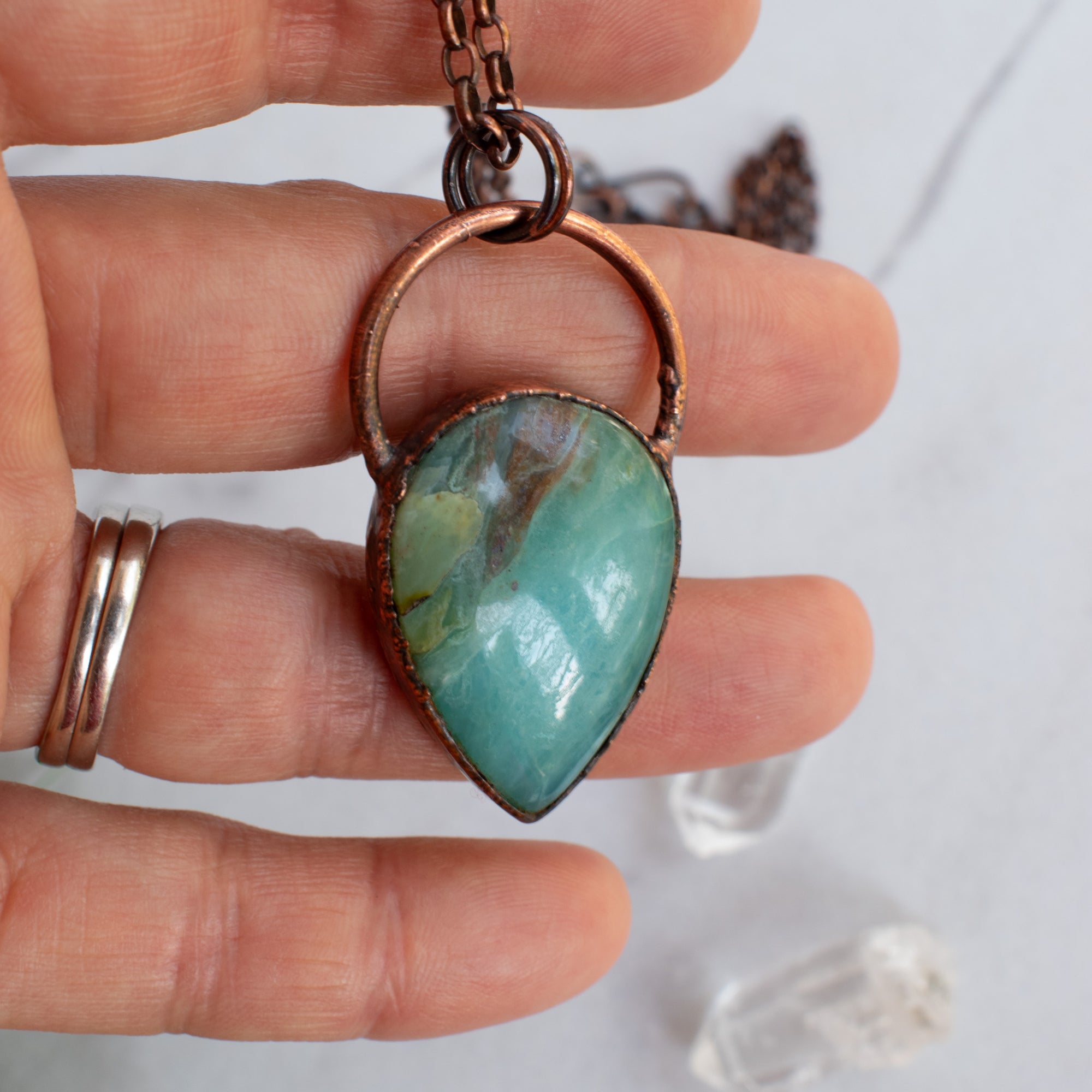 Peruvian Blue Opal and Copper pendant shown in a human hand.