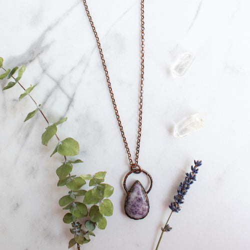 Lepidolite and Copper electroformed necklace shown beside green eucalyptus branch and lavender.