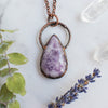 Lepidolite and Copper electroformed necklace shown beside green eucalyptus branch, Quartz crystals and lavender.