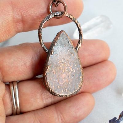 Back detailing of the copper electroformed pendant, shown held in hand.