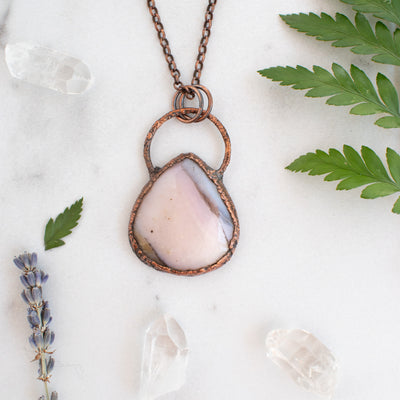 Australian Pink Opal and Copper necklace shown beside greenery, lavender and Quartz crystals.