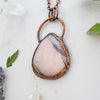 Side angle showing the Australian Pink Opal and Copper necklace beside greenery, lavender and Quartz crystals.