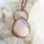 Soothing Pink Australian Opal and copper pendant shown against a Quartz background.