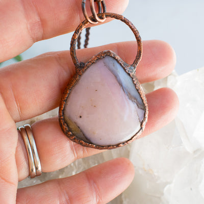 Pink Opal and Coper electroformed pendant held in a human hand.