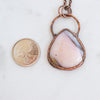 Australian Pink Opal and copper electroformed pendant shown beside a Canadian Quarter coin.