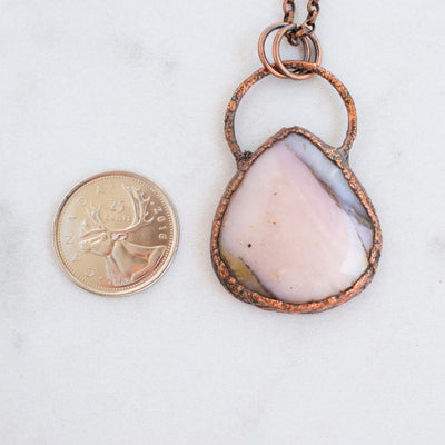 Australian Pink Opal and copper electroformed pendant shown beside a Canadian Quarter coin.