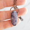 Lepidolite and Copper electroformed pendant shown in human hand.