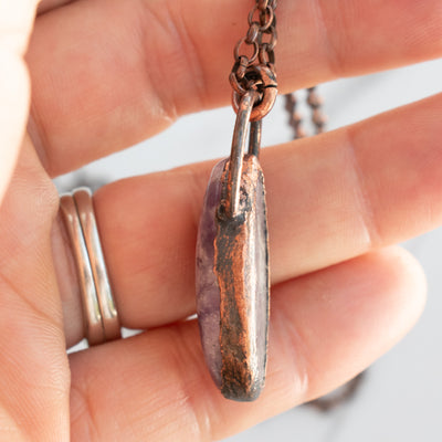 Lepidolite and Copper electroformed pendant shown in human hand, side view details showing.