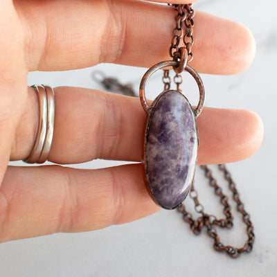 Lepidolite and Copper electroformed pendant shown in human hand.