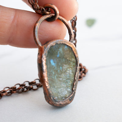 Backside of the Labradorite and copper pendant showing the flashes and sparkles of the back of the stone.