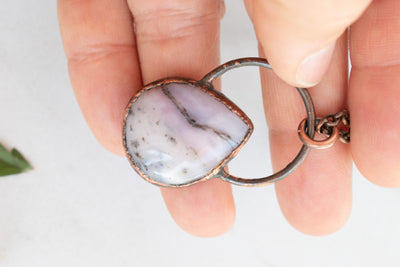 Soothing Pink Australian Opal and copper pendant shown in hand.