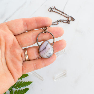 Soothing Pink Australian Opal and copper pendant shown in hand.