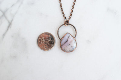 Copper and Australian Pink Opal electroformed necklace shown beside a Canadian quarter coin.