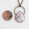 Copper and Australian Pink Opal electroformed necklace shown beside a Canadian quarter coin.