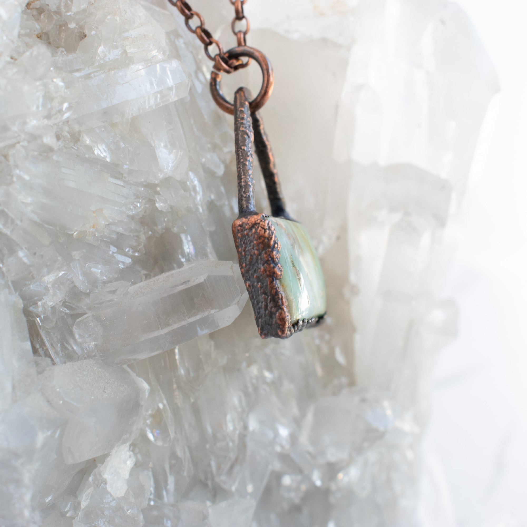 Side detail shown on this Peruvian Blue Opal and Copper pendant shown in front of a Quartz cluster.