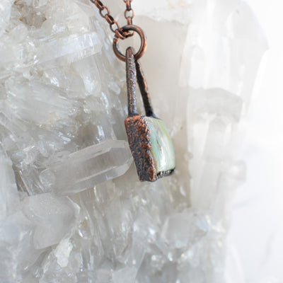 Side detail shown on this Peruvian Blue Opal and Copper pendant shown in front of a Quartz cluster.