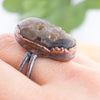 Side view of a Copper and Labradorite Skull ring shown worn on a hand.