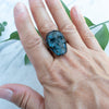 Blue Labradorite and Copper Skull RIng worn on a hand.