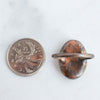 Back view of a Peach Moonstone and Copper Ring shown beside a Canadian Quarter coin.