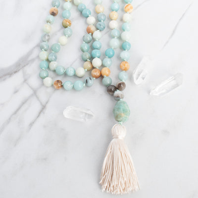 Soothing tones of blue, cream and brown blend together in this hand knotted Amazonite Mala necklace with hand tied silk tassel.