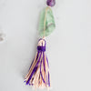 Green, clear and purple banding can be seen in the Rainbow Flourite Guru bead, alongside the handmade pink and purple tassel.