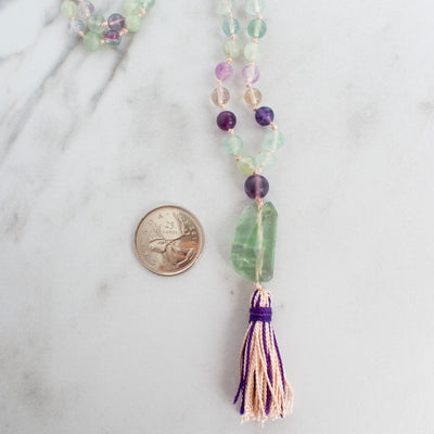 Rainbow Flourite Mala necklace shown beside a Canadian Quarter coin.