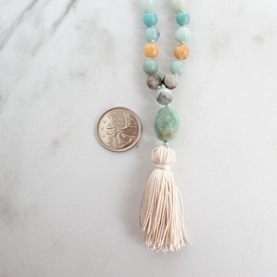 Blue Amazonite Guru bead beside a Canadian Quarter coin.