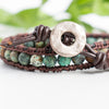 Close up photo shows the details of the African Turquoise beads and silver toned button in this leather and hemp wrap bracelet.