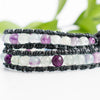 Close up showing the detailing of black hemp around the black leather cord and purple, clear and green Fluorite beads.