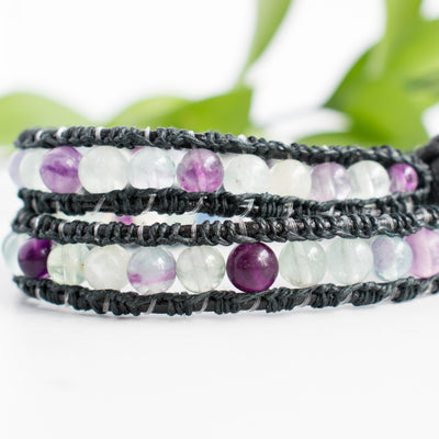 Close up showing the detailing of black hemp around the black leather cord and purple, clear and green Fluorite beads.