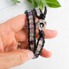 Woman's hand holding the Fluorite and leather wrap bracelet.