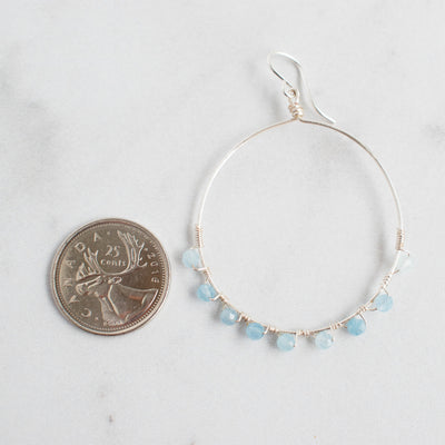 Aquamarine and Silver plated Hoop earrings next to a Canadian Quarter.