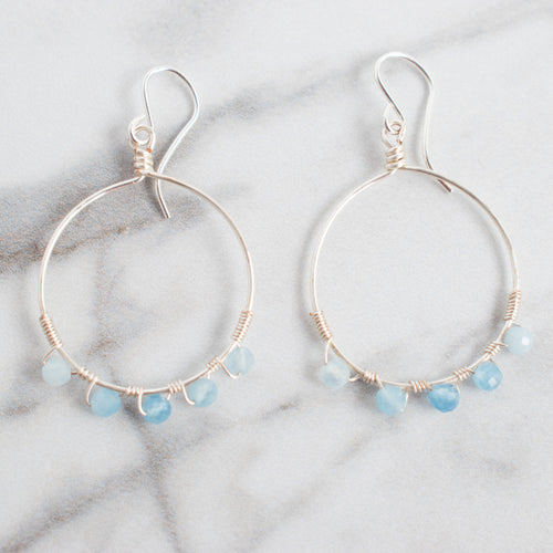 Close up photo shows the details of these silver plated wire wrapped Aquamarine Hoop earrings
