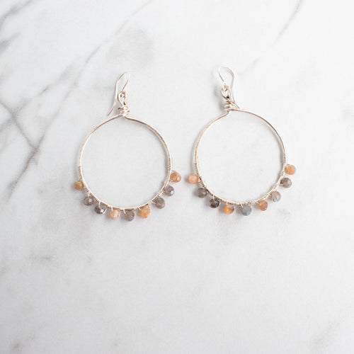 Moonstone and silver plated hoop earrings on a white background.