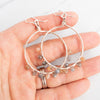 Silver plated grey and peach Moonstone hoop earrings shown held in a hand.