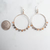 Moonstone and silver plated hoop earrings shown next to a Canadian Quarter for size reference.