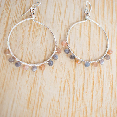 Peach and Grey Moonstone Silver plated hoop earrings shown against a wooden background.