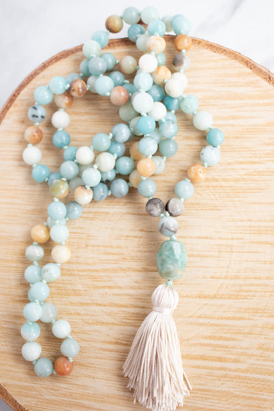 Soothing tones of blue, cream and brown blend together in this hand knotted Amazonite Mala necklace with hand tied silk tassel.