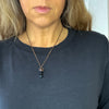 A Black Tourmaline and copper necklace is worn by a woman in a black shirt.